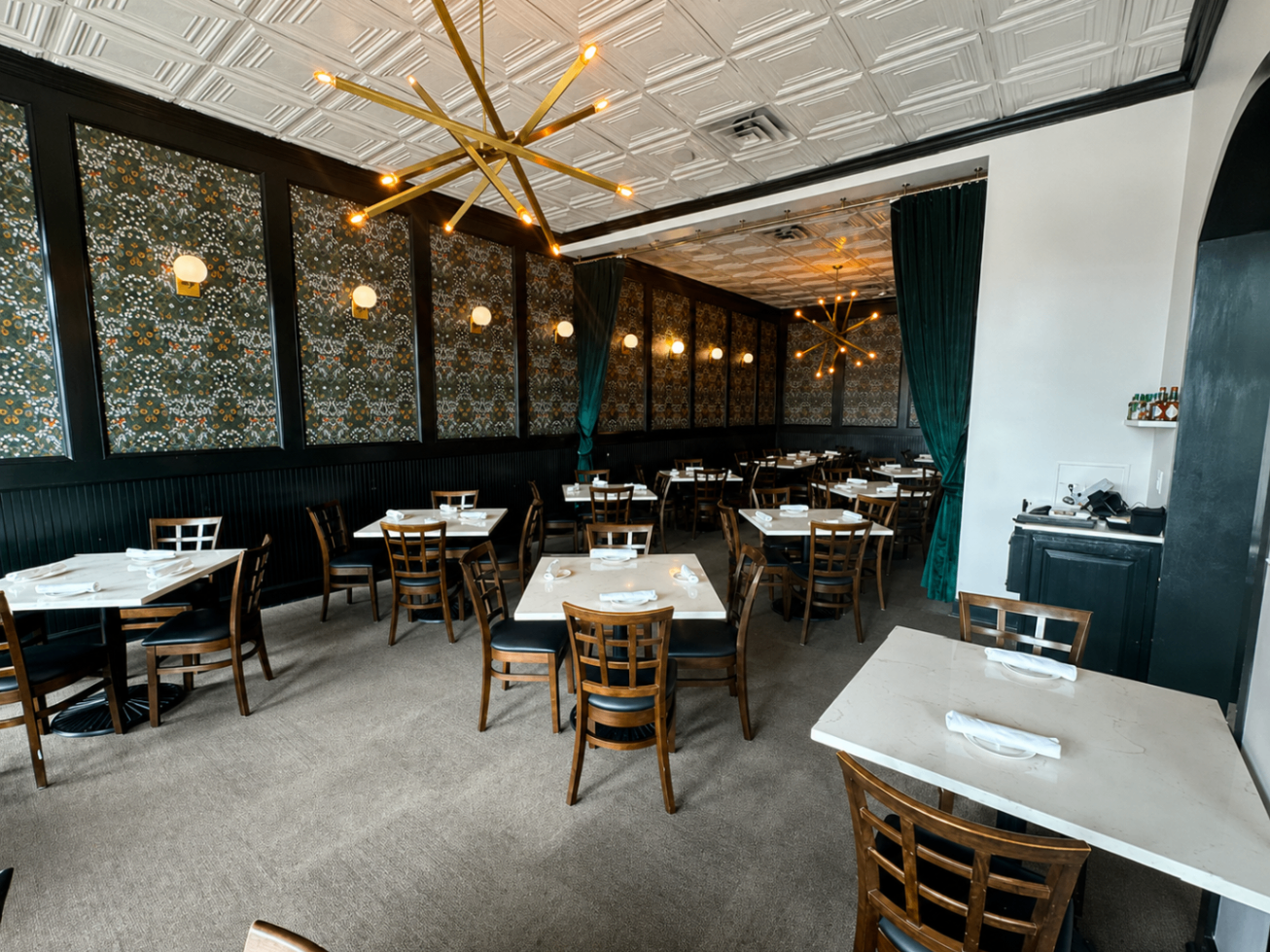 Dining room with floral wallpaper and gold light fixtures at Romacelli