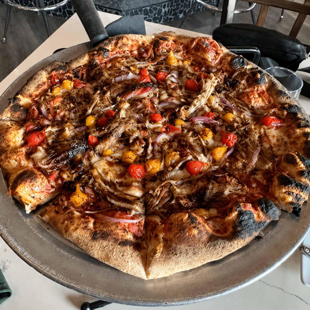 Wood-fired BBQ chicken pizza with peppers at Romacelli